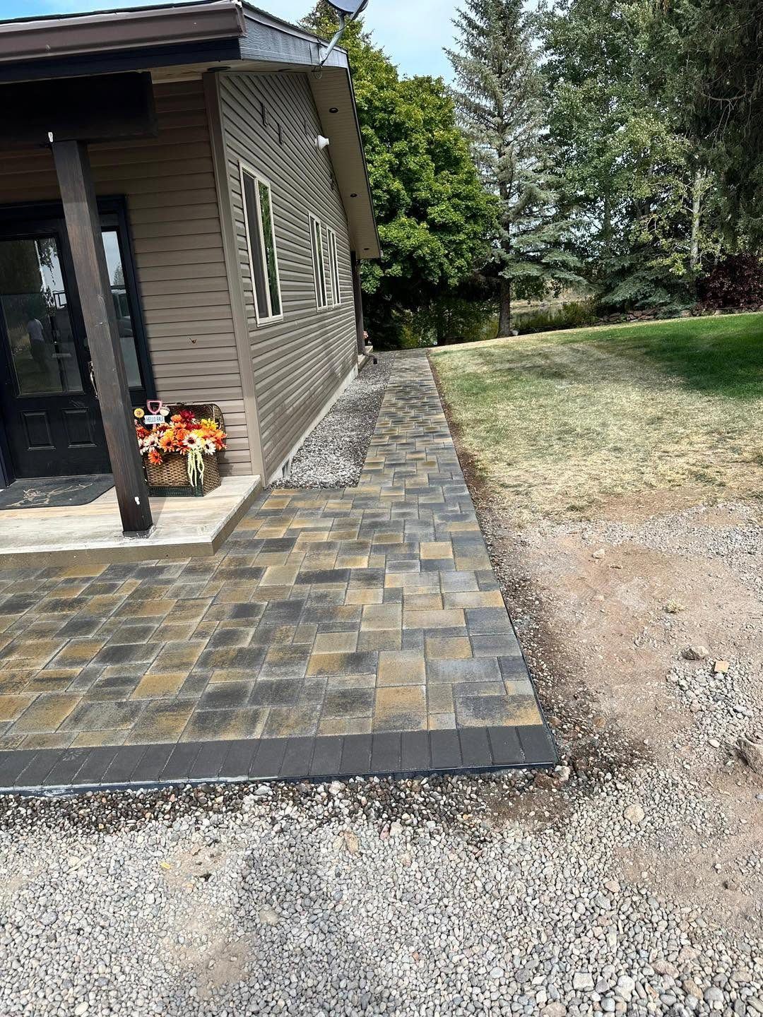 Tan paver walkway and landing wrapping around the side of a home